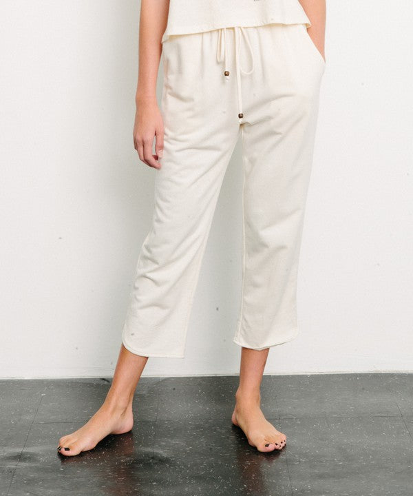 Ivory organic hemp and cotton joggers with a drawstring waist and cropped leg against a white background