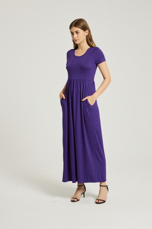 Soft deep purple rayon maxi dress with an empire waist short sleeves and pockets on a brunette model.