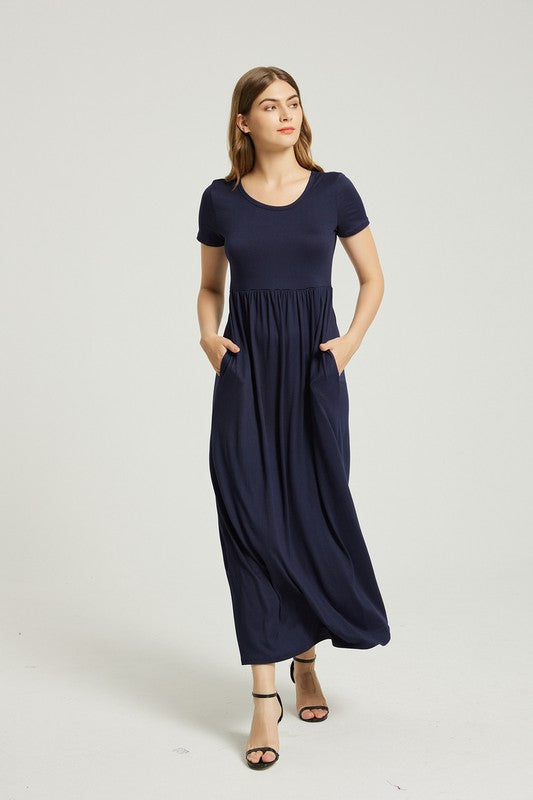 Brunette model wearing a navy blue casual maxi dress with short sleeves and pockets.