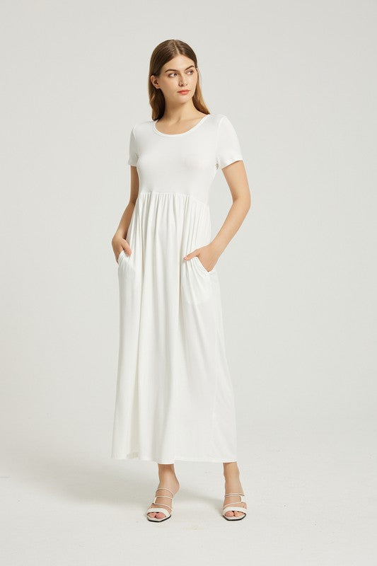 Brunette model wearing a white short sleeve maxi dress with pockets.