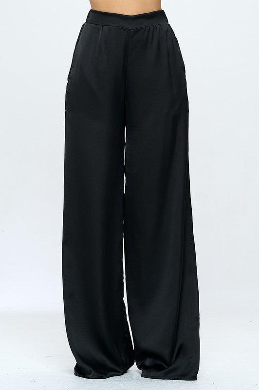 Stretchy satin dress pants with pockets and elastic waist on a white background.