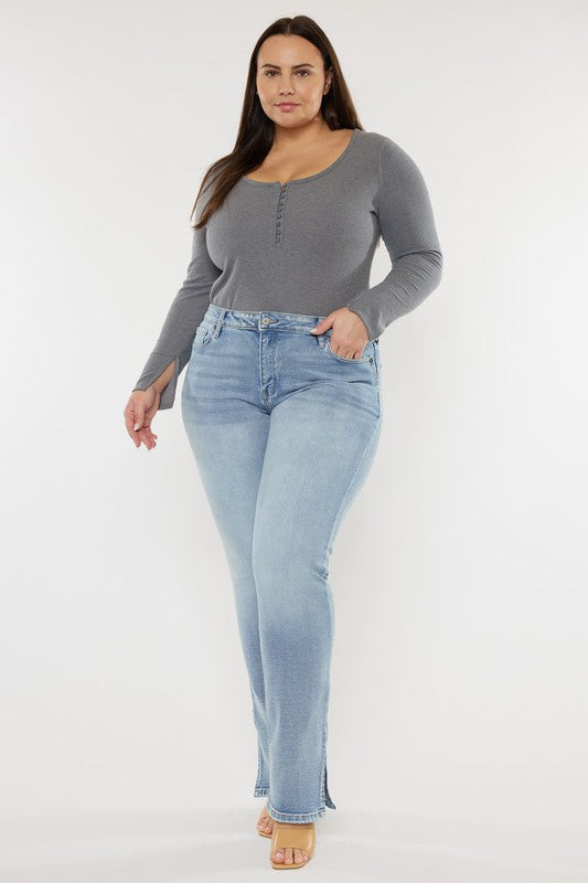 Plus size model with brown hair wearing a grey long sleeved top with light wash plus mid rise Y2K Bootcut jeans
