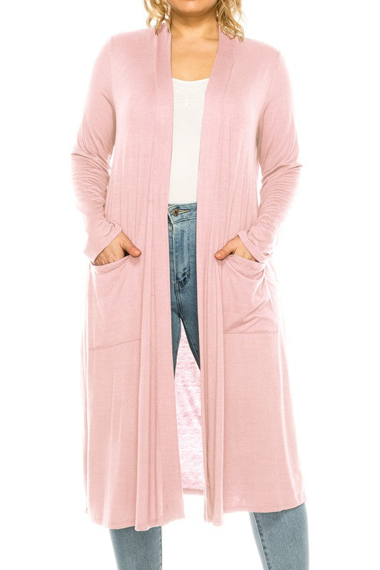 Lightweight plus size light pink duster cardigan with front pockets on a blonde plus size model against a white backdrop.
