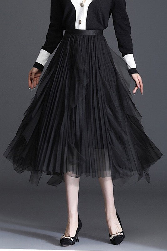 Black chiffon pleated midi skirt on a model wearing black pumps and a black and white shirt