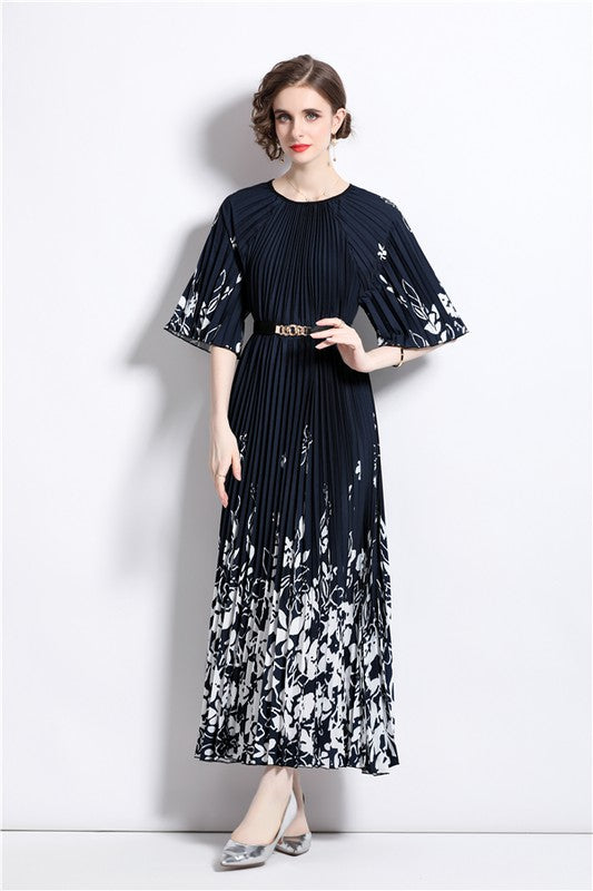Brunette model wearing a half-sleeve pleated midi dress in black with white floral. One size, fits standard to plus sizes.