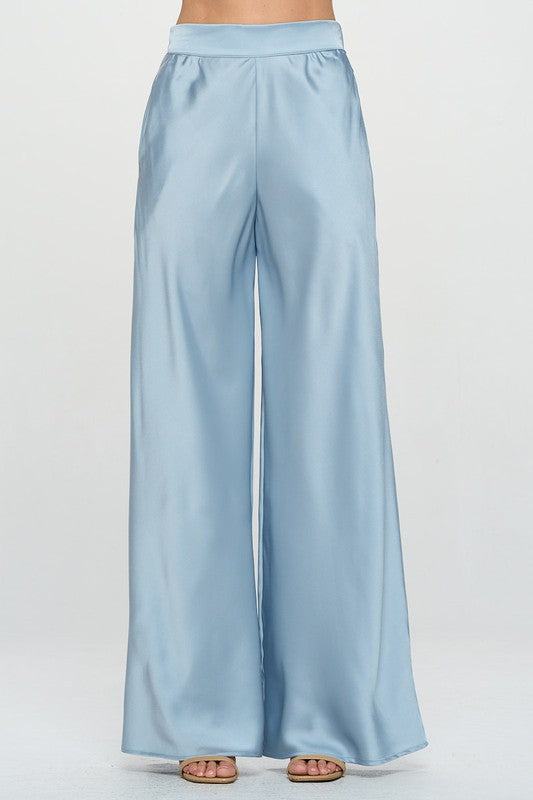 Light blue satin stretchy pants with elastic waist and pockets on a white background