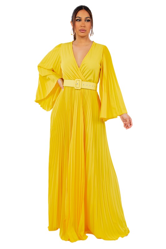 Brunette model wearing a flowy, long bell sleeve pleated maxi dress in sunny yellow against a white backdrop.