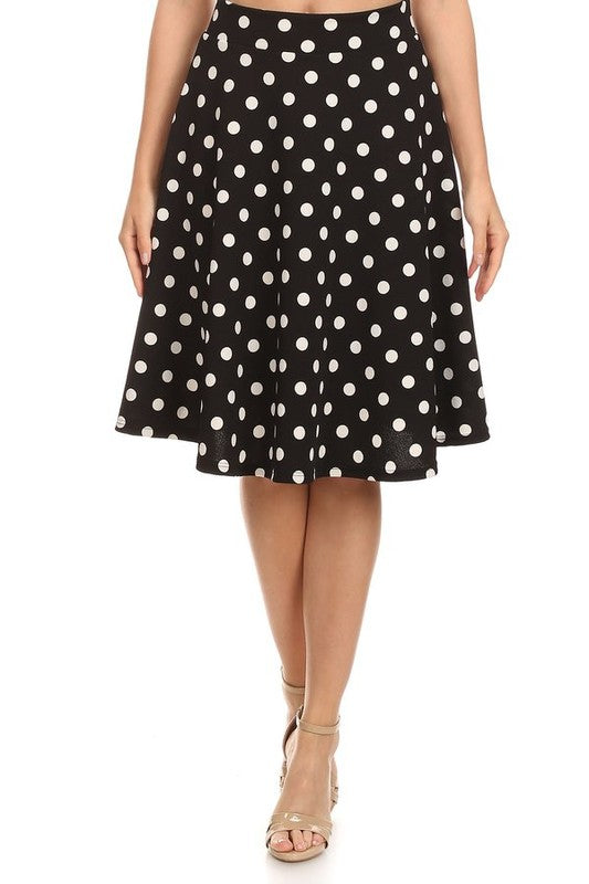 Model wearing black skirt with white polka dots on a white backdrop.