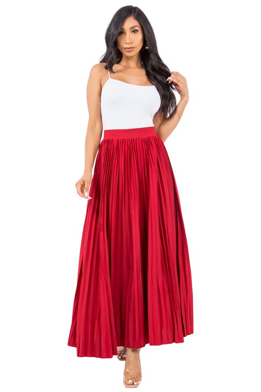 Model with long dark hair wearing a red pleated maxi skirt with a cami top.