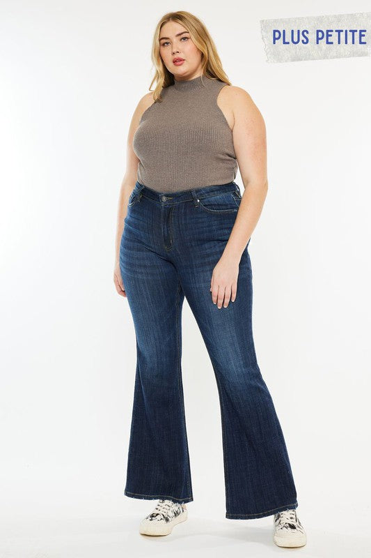 Blonde Plus size model with blonde hair wearing sneakers and a brown tank top with plus petite dark wash mid rise flare jeans.