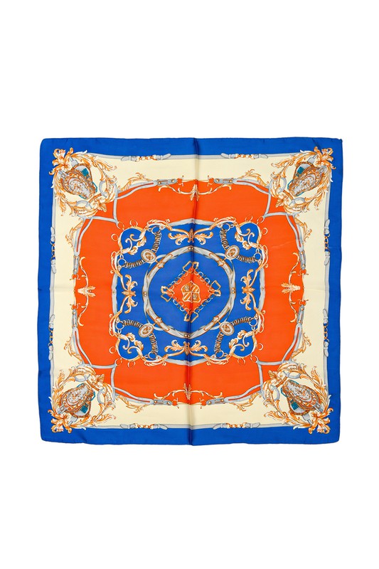 Geometric pattern printed scarf in a white, orange, and blue pattern.