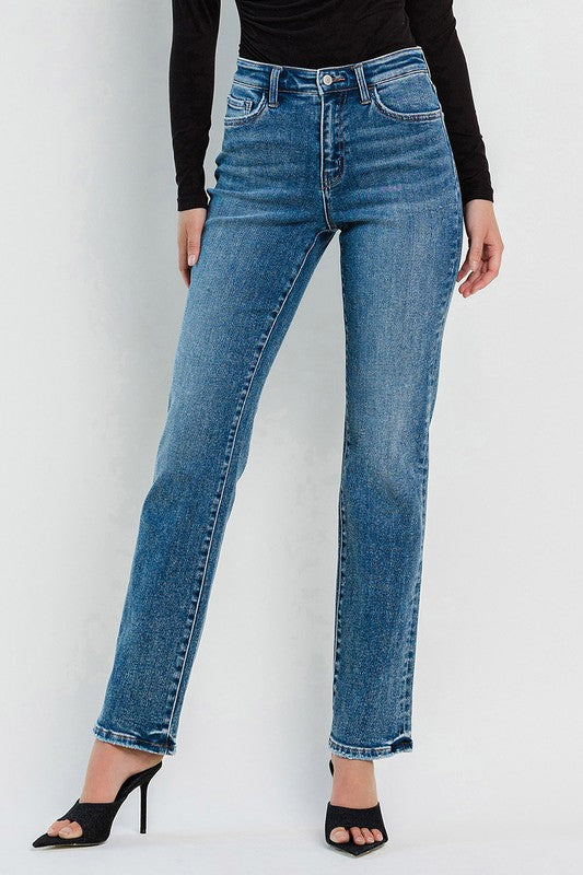 Model wearing high rise straight leg jeans with a black long sleeved shirt and kitten heels.
