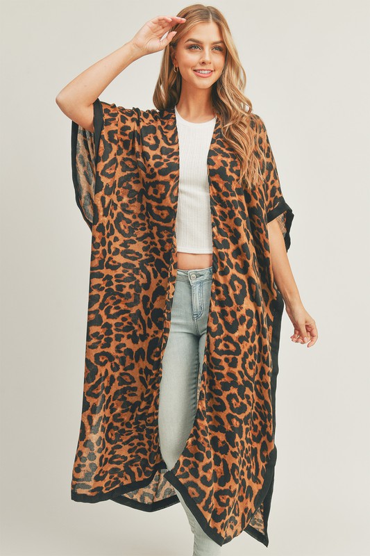 Up your casual fashion game with this long and loose open front kimono with a leopard print worn by a blonde model in light blue jeans and a white tee.