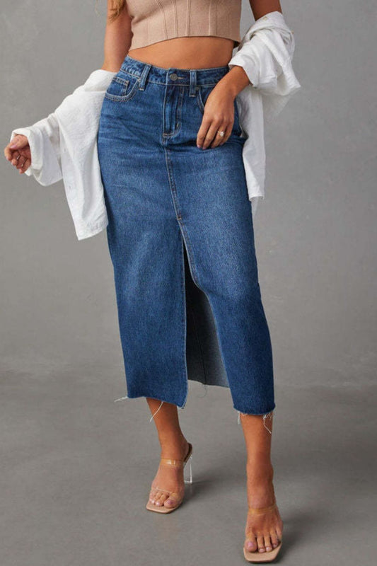 Model wearing Midi length denim skirt with front slit and raw hem against a grey backdrop