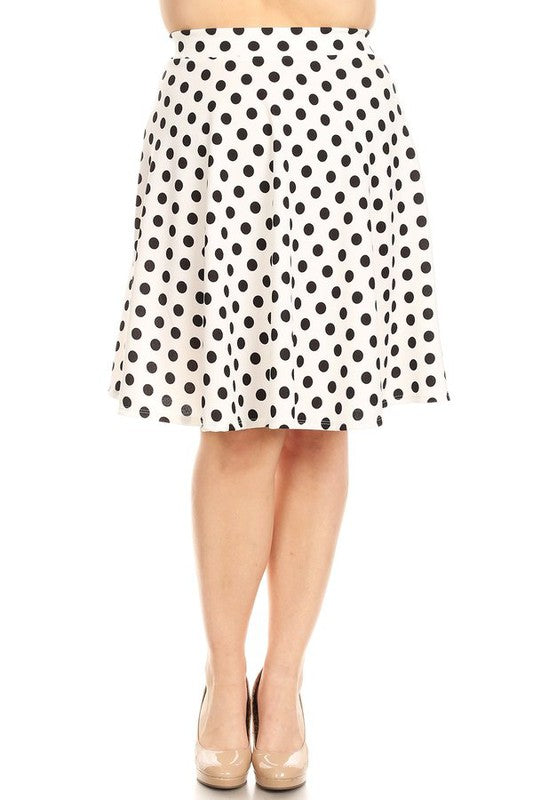 Plus size model wearing a white knee length skirt with black polka dots against a white backdrop.