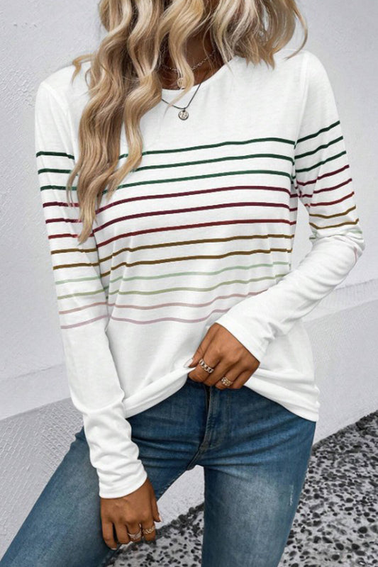 Blonde model wearing a white, long-sleeve tee with multicolor thin stripes. Available in several colors.
