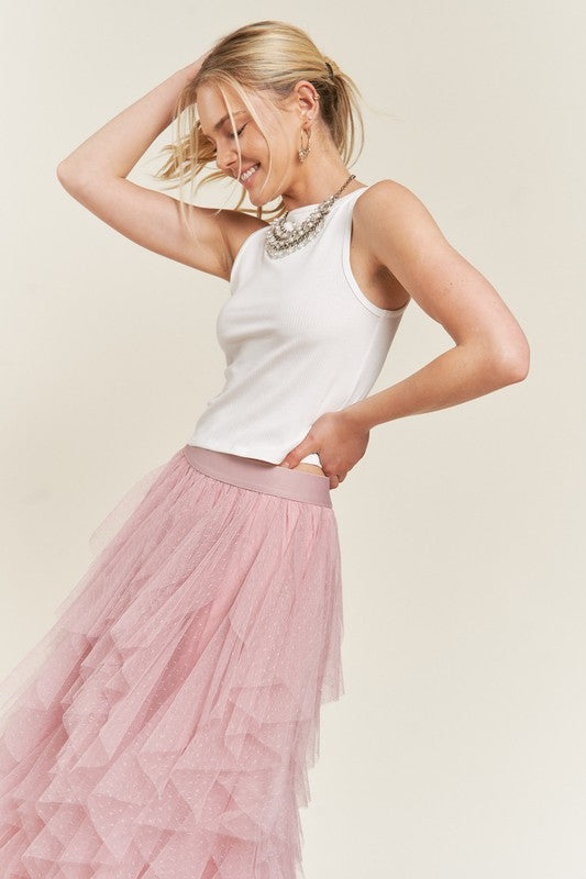 Pink layered a-line polka dot tulle midi skirt on a blonde model wearing a statement necklace and tank top.