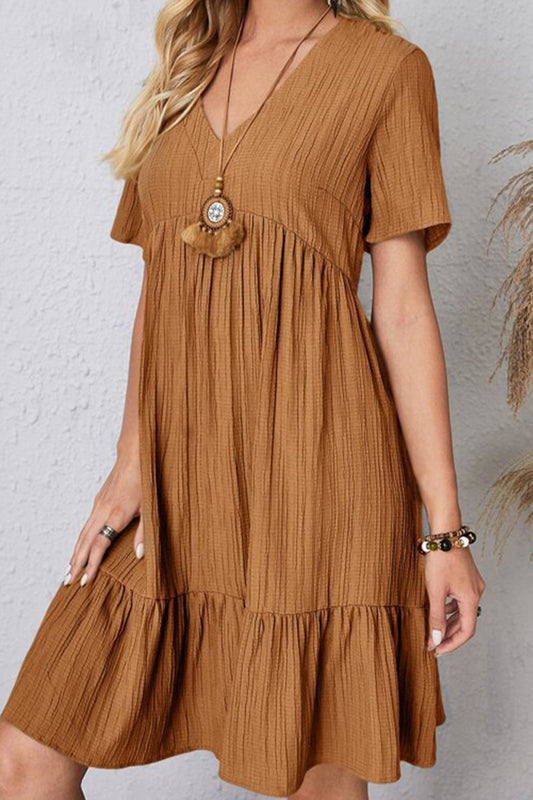 Blonde model wearing a cute cotton-blend textured knee-length dress with a v-neck and short sleeves in caramel.