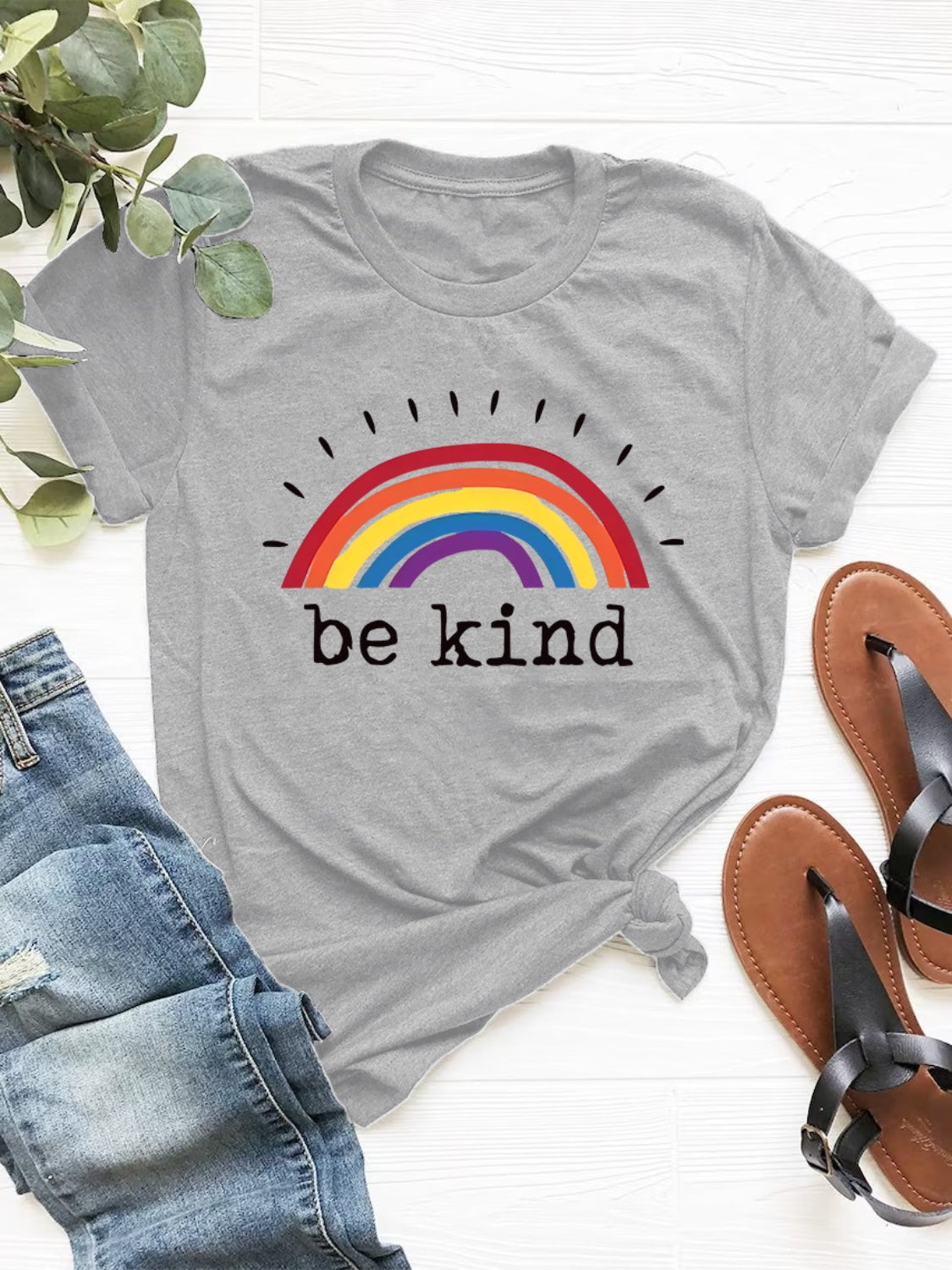 Pride "Be kind" graphic tee with a colorful rainbow on the center, shown in grey and also available in pink or white.