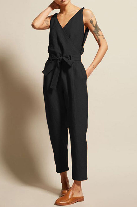 Model in front of an ecru background wearing a black surplice top sleeveless jumpsuit with a cropped bottom. 