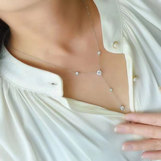 Model in a white shirt wearing a sterling silver and moissanite y-necklace.
