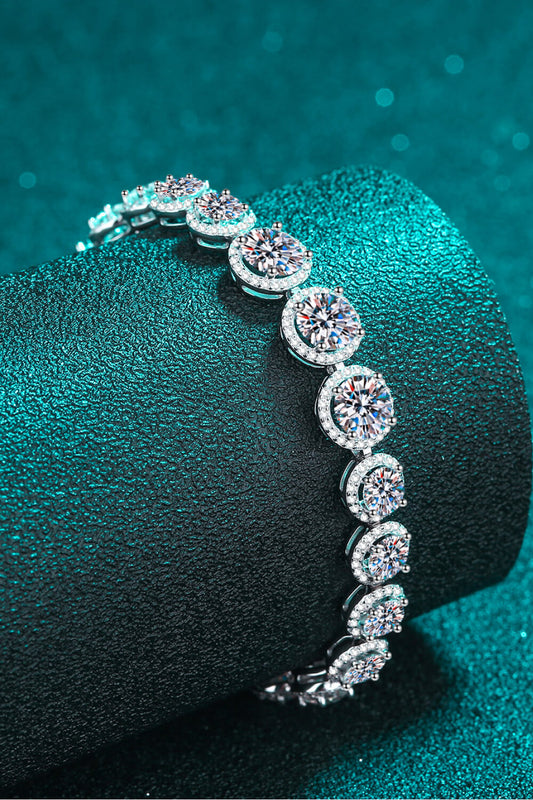 Stunning 10.4 carat Moissanite tennis bracelet with round stones surrounded by zircon accents on a teal background.