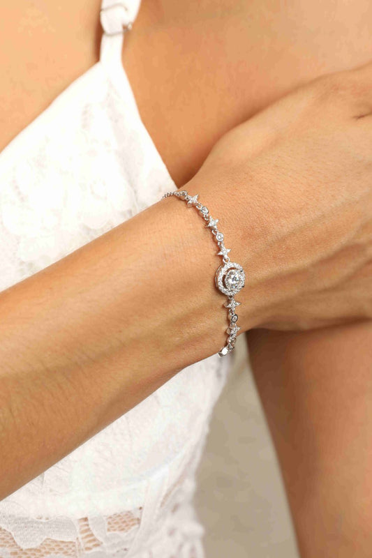 Woman in a white corset wearing a rhodium plated sterling silver moissanite bracelet with an antique look.