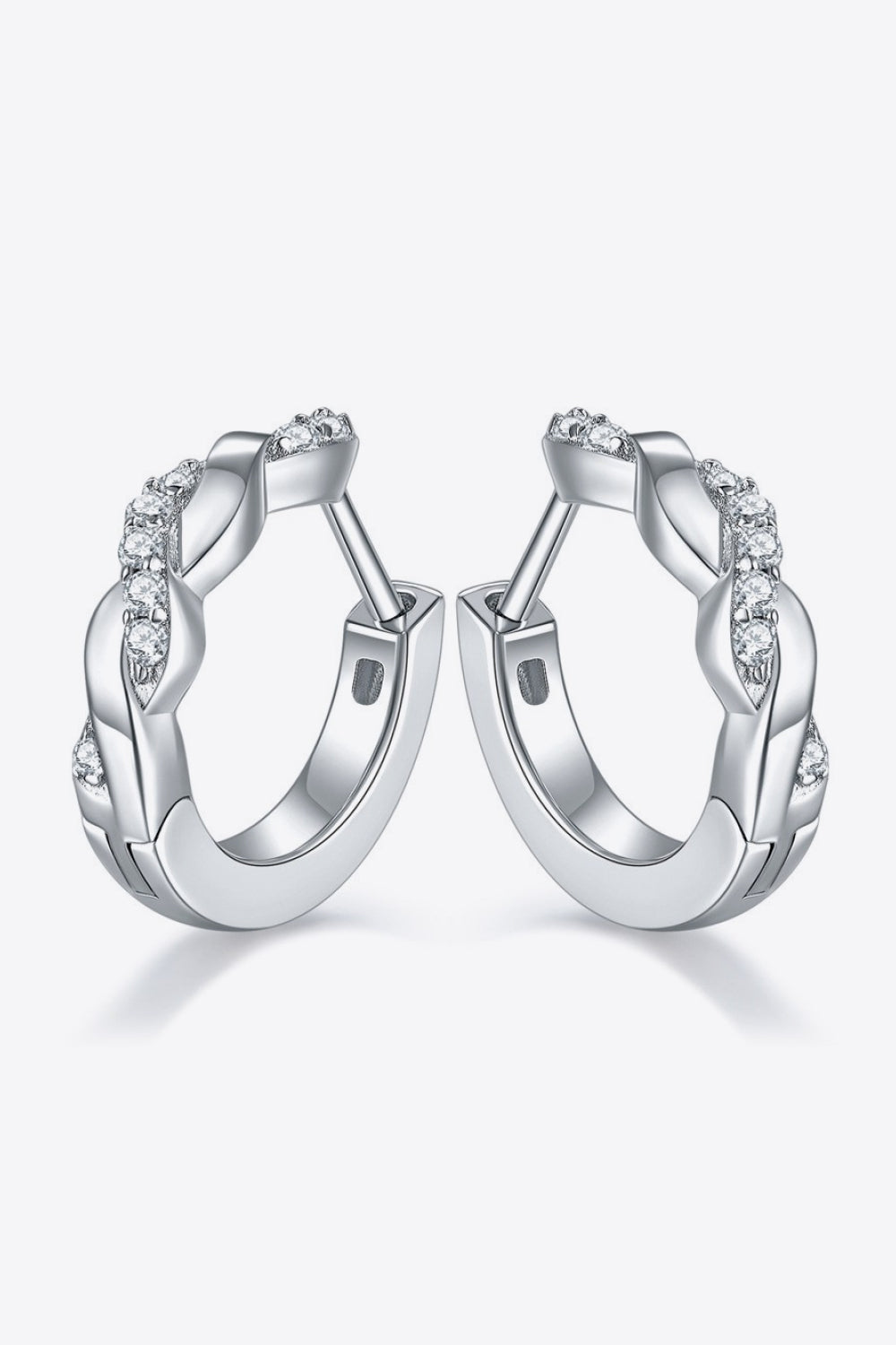 Pair of platinum-plated sterling silver earrings in a twisted, crossover design with several small moissanite stones on a white background.