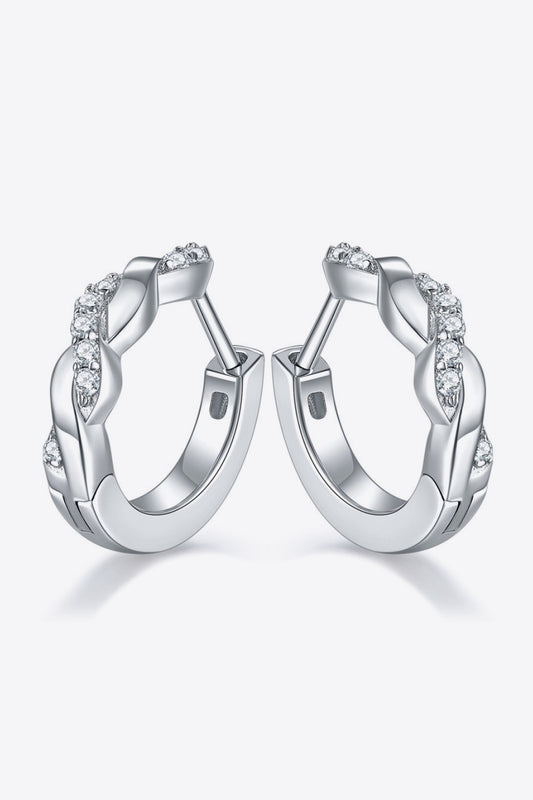 Pair of platinum-plated sterling silver earrings in a twisted, crossover design with several small moissanite stones on a white background.