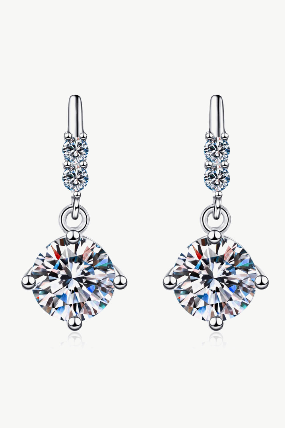 Pair of rhodium plated sterling silver with .5 carat round Moissanite stone in each, accented by two small zircon on a white background.moissanite earrings with 