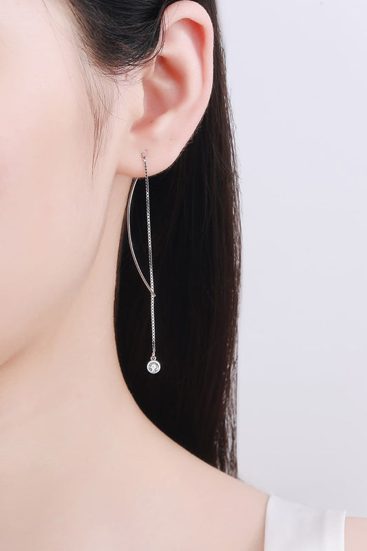 Woman with long brown hair wearing long threader earrings with Moissanite on the bottom.